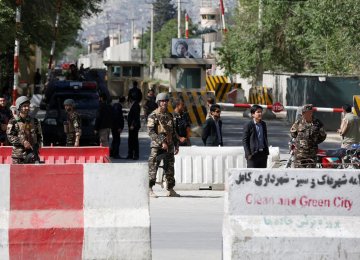 Afghan security forces stand guard near the site of a blast in Kabul on April 30.
