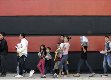Immigrant families walk along a sidewalk on their way to a respite center after they were processed and released by US Customs and Border Protection on June 24 in McAllen, Texas.