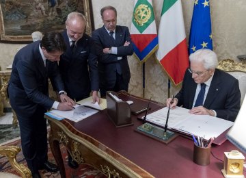 Italy’s Prime Minister-designate Giuseppe Conte (L) and Italian President Sergio Mattarella sign documents at the Quirinal Palace in Rome on May 31.