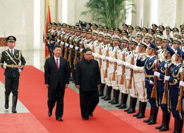 Kim Jong-un (R) inspecting an honor guard while accompanied by Chinese President Xi Jinping during a welcoming ceremony at the Great Hall of the People in Beijing on June 19.