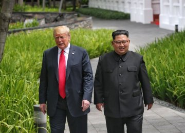 US President Donald Trump walks with North Korean leader Kim Jong-un  at the Capella Hotel on Sentosa island in Singapore on June 12.  