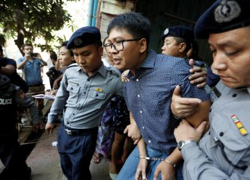 Detained Reuters journalist Wa Lone  is escorted by police after a court hearing in Yangon, Myanmar, on April 11.