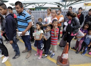 Immigrant families line up after they were processed and released by US Customs  and Border Protection on June 24 in McAllen, Texas. 
