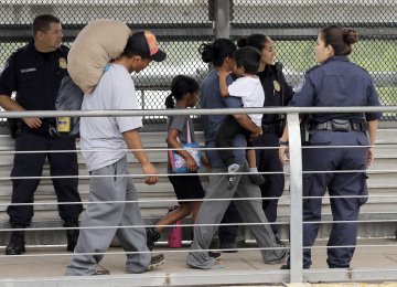 Immigrants from Honduras are escorted back across the border by US Customs and Border Patrol agents on June 21 in Texas.