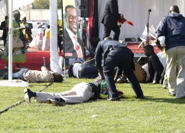 Injured people lay on the ground following an explosion at a ZANU-PF rally in Bulawayo on June 23.