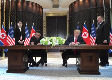 US President Donald Trump and North Korea's leader Kim Jong-un sign documents as US Secretary of State Mike Pompeo (R) and the North Korean leader's sister Kim Yo Jong (L) look on at a signing ceremony during the US-North Korea summit, at the Capella Hotel on Sentosa island in Singapore on June 12.