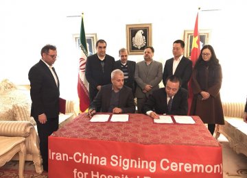 The agreement with Chinese lenders was signed in Beijing in the presence of Iran’s Health Minister Hassan Qazizadeh Hashemi (back left).