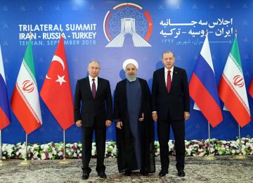President Hassan Rouhani (C) stands next to Russian President Vladimir Putin (L) and Turkish President Recep Tayyip Erdogan ahead of a trilateral summit in Tehran on Friday.