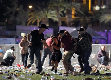 People carry a peson at the Route 91 Harvest country music festival after gun fire in Las Vegas, Nevada. (Photo: AFP)