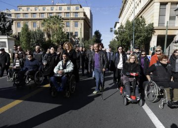 Disabled people with their families march during an  anti-government rally in central Athens on Friday, Dec. 2.