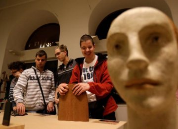 Blind people touch sculptures during a special exhibition for people with visual disabilities in Prague, Czech Republic.
