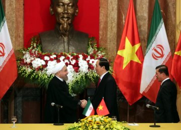 President Hassan Rouhani (L) shakes hands with Vietnamese President Tran Dai Quang in Hanoi, Vietnam, on Oct 6.