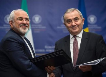 Foreign Minister Mohammad Javad Zarif (L) shakes hands with his Romanian counterpart, Lazar Comanescu, in Bucharest on Nov. 9.    