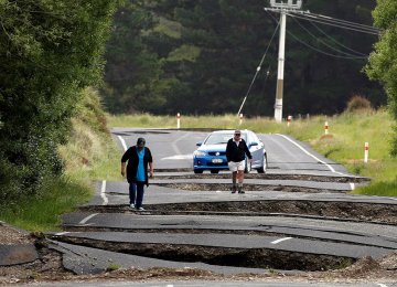 Local residents look at damage caused by an earthquake along State Highway One near the town of Ward, south of Blenheim on New Zealand's South Island on Nov. 14.