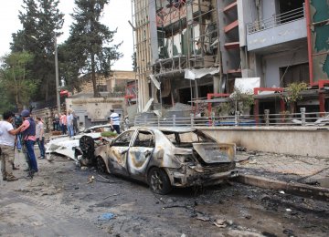 Journalists and civilians stand near the damage after rockets fired by insurgents hit the al-Dabit maternity clinic in  government-held parts of Aleppo city, Syria. (File Photo)