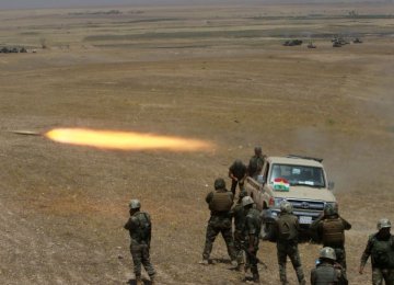 Kurdish Peshmerga forces fire a rocket toward IS militants on the southeast of Mosul, Iraq, on Aug. 14.