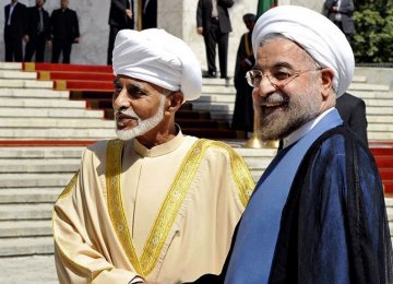 President Hassan Rouhani (R) greets Oman’s Sultan Qaboos bin Said at the presidential palace in Tehran on August 25, 2013.