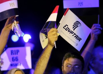 People hold EgyptAir flags during a candlelight vigil for the victims of Flight 804 in Cairo, Egypt, on May 26. (File Photo)