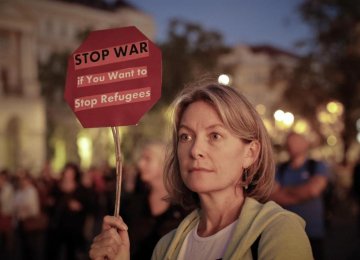 A woman holds a banner during a protest against PM Orban’s policies regarding migrants in Budapest, Hungary, on Sept. 30.