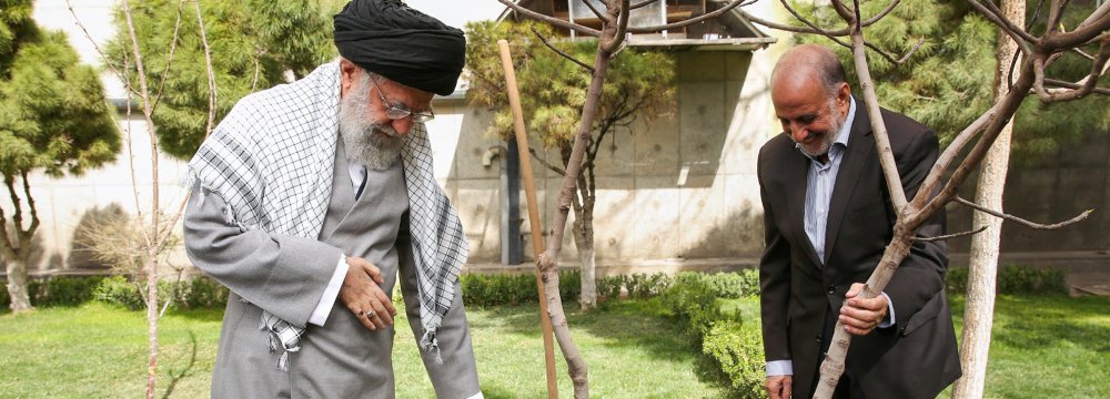 Ayatollah Seyyed Ali Khamenei plants two saplings in Tehran to mark National Tree Planting Day and the beginning of Natural Resources Week on March 6.