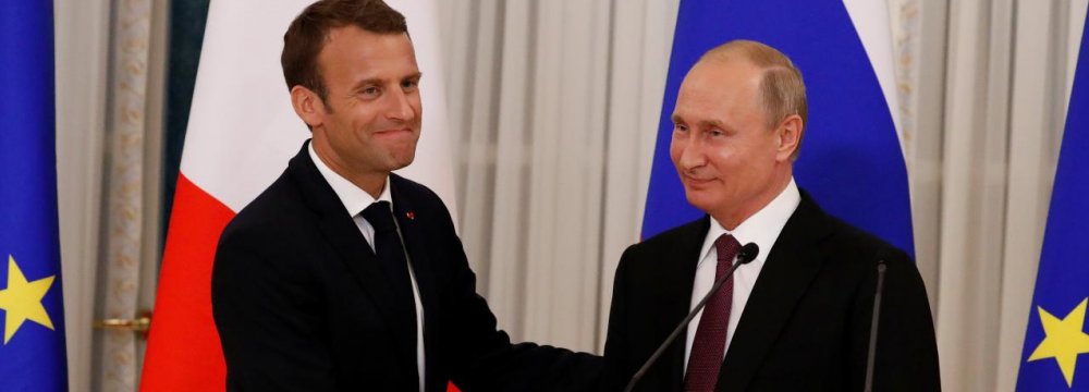 President Vladimir Putin (R) and his French counterpart Emmanuel Macron shake hands as they leave after a news conference in St. Petersburg on May 24.