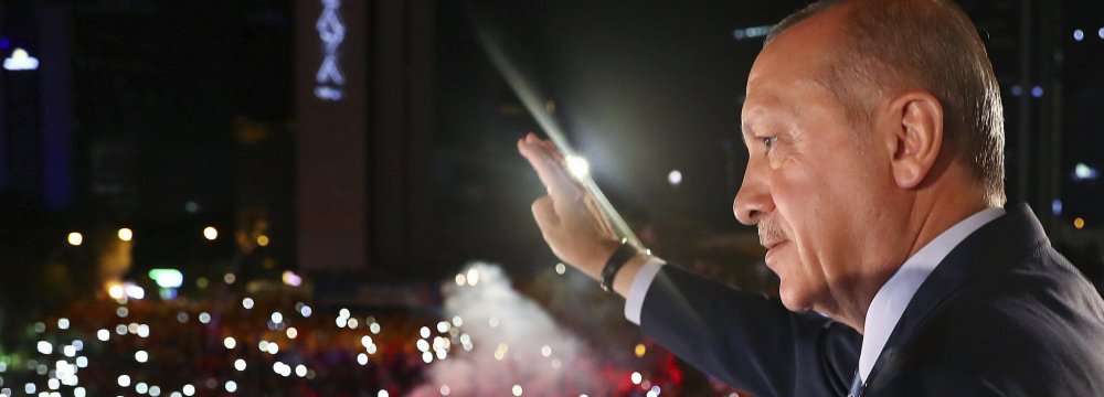 Turkish President Recep Tayyip Erdogan greets supporters gathered in front of the AKP headquarters  in Ankara, on June 25. 
