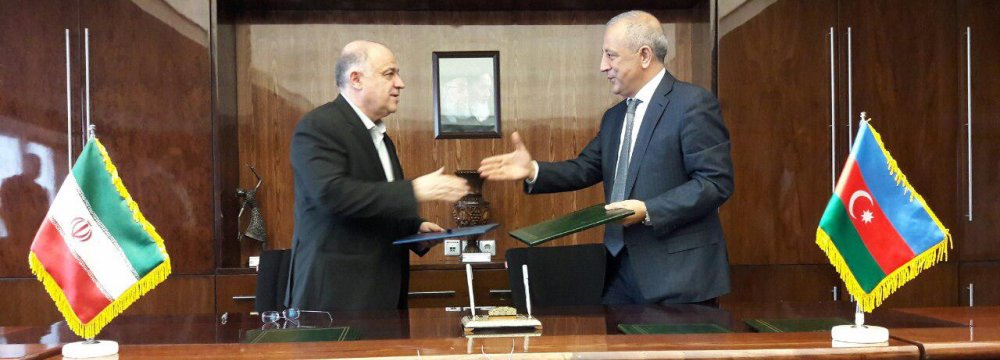 Iran's Deputy Minister of Energy Homayoun Haeri (L) and his Azerbaijani counterpart Natiq Abbasov signed an agreement in Tehran on April 12.