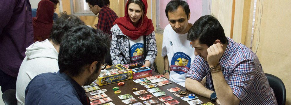 A group of young gamers play at a center in Tehran on the International Tabletop Day in 2017.