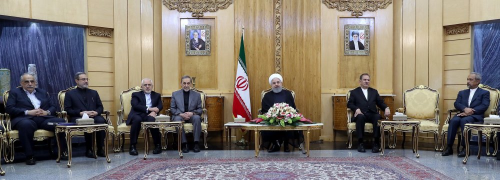 President Hassan Rouhani (C) talks to reporters in Tehran on Friday before flying to China.