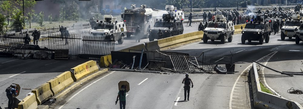 Opposition activists and riot police clash during a protest against President Nicolas Maduro in Caracas.