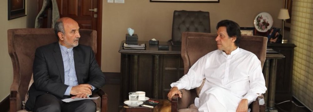 Pakistan Tehreek-e-Insaf Chairman Imran Khan (R) talks with Iranian Ambassador Mehdi Honardoost in Islamabad on Saturday.
