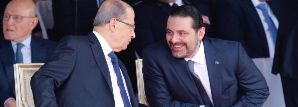 Saad al-Hariri (R) talks with President Michel Aoun while attending a military parade to celebrate  the 74th anniversary of Lebanon’s independence in Beirut, Nov. 22.