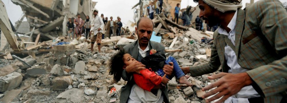 A man carries a five-year-old child rescued from the site of a Saudi-led airstrike that killed eight of her  family members in Sanaa, Yemen, August 25.
