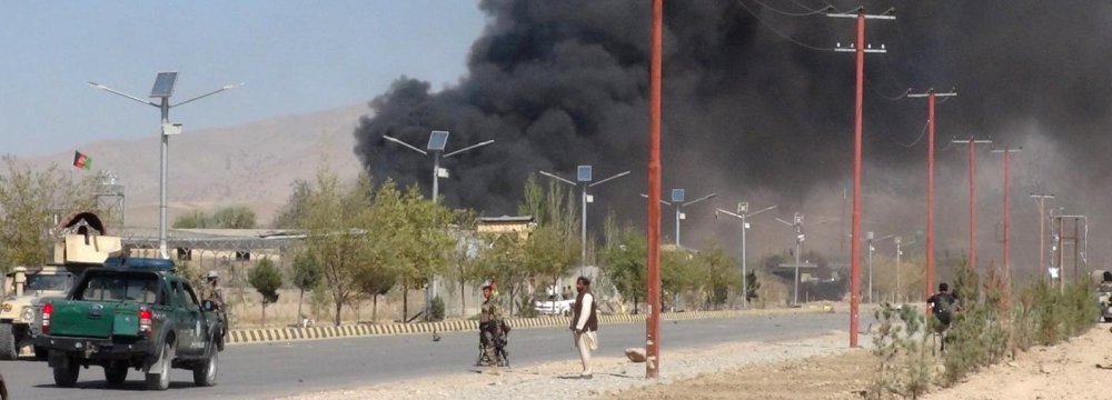 Smoke rises from police headquarters while Afghan security forces keep watch after a suicide car bomber and gunmen attacked the provincial police headquarters in Gardez, the capital of Paktia Province, Afghanistan on October 17.