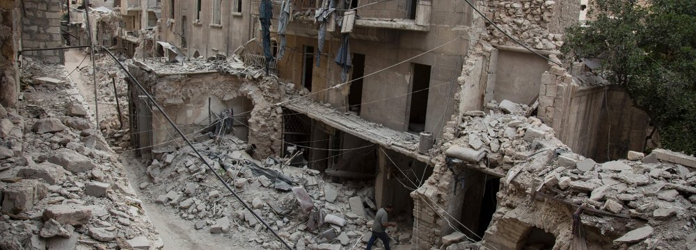 A man walks past destroyed buildings in Aleppo, Syria, in May 2016.