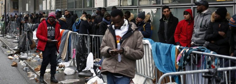 Migrants queue outside a facility to apply for asylum,  in Paris, Dec. 21.