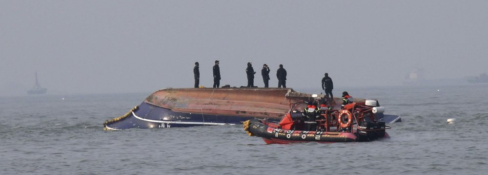 South Korean Coast Guard officers try to rescue a capsized fishing boat which collided with a refueling vessel in the waters off Incheon, South Korea on Dec. 3.