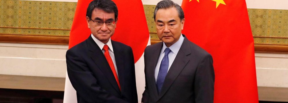 Japanese Foreign Minister Taro Kono (L) and Chinese counterpart, Wang Yi, pose for photograph before their meeting in Beijing on Jan. 28. 