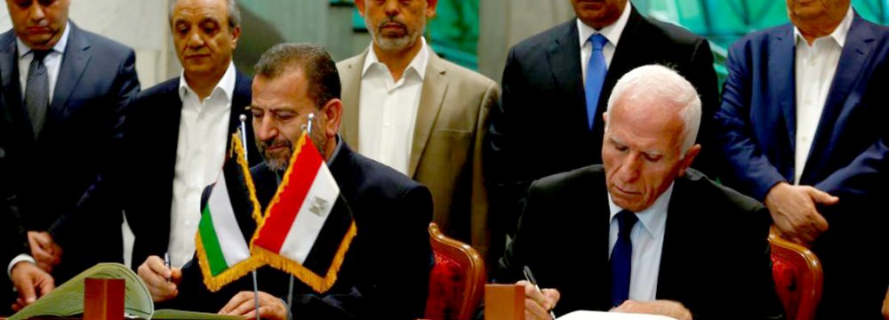 Head of Hamas delegation Saleh Arouri (L) and Fatah leader Azzam Ahmad sign a reconciliation deal in Cairo, Egypt on October 12.