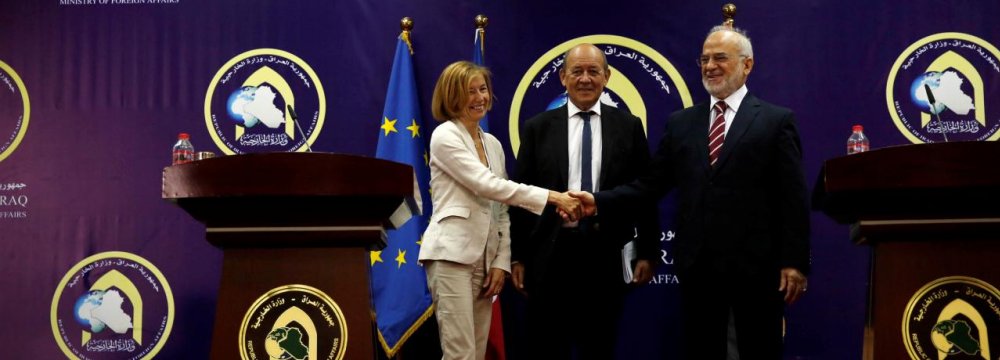 French Defense Minister Florence Parly (L) shakes hands with Iraqi Foreign Minister Ibrahim al-Jaafari with French Foreign Minister Jean-Yves Le Drian present during a joint news conference in Baghdad on August 26.