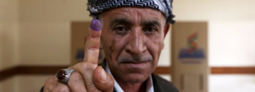 A Kurdish man shows his inked index finger after voting in an independence referendum in Erbil, Iraq on Sept. 25