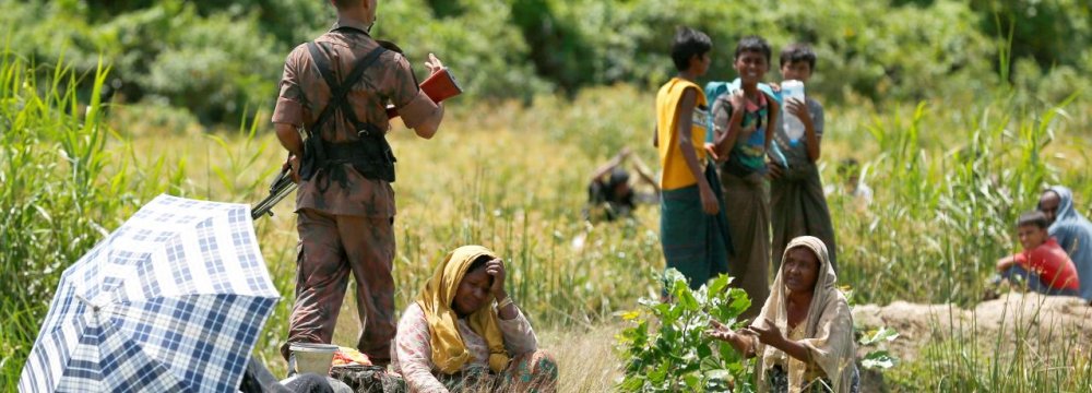 A Rohingya woman urges a member of Border Guard Bangladesh not to turn them back to Myanmar, in Cox’s Bazar, Bangladesh on August 27.