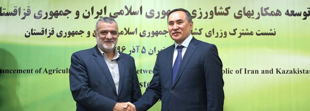 Iran’s Minister of Agriculture Mahmoud Hojjati (L) shakes hands with Kazakhstan’s Deputy Prime Minister and Minister of Agriculture Askar Myrzakhmetov in Tehran on Sunday.