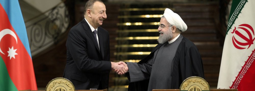 Azerbaijani President Ilham Aliyev (L) shakes hands with Iran’s President Hassan Rouhani in Tehran  on March 5.