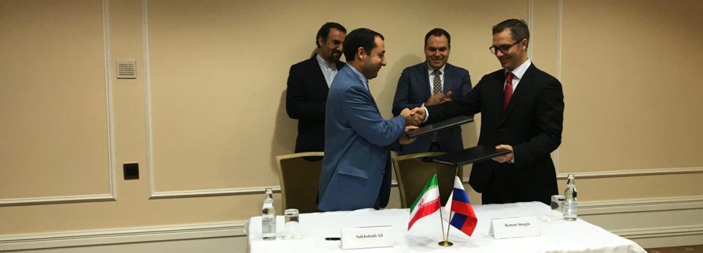 Ali Salehabadi (L), the head of Iran Eximbank,  and his Russian counterpart shake hands after  signing the finance deal in Moscow. 