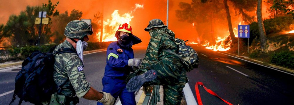 Firemen and soldiers escape from spreading flames near Athens.