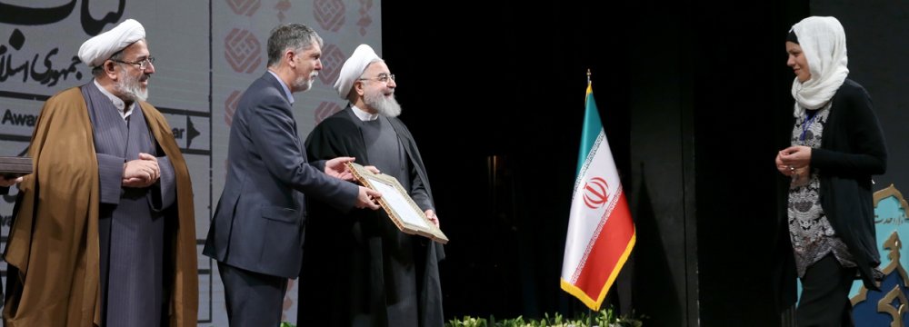 Silvia Balatti from University of Kiel, Germany,(R) receives her award from President Hassan Rouhani (C)  and Culture Minister Seyyed Abbas Salehi.