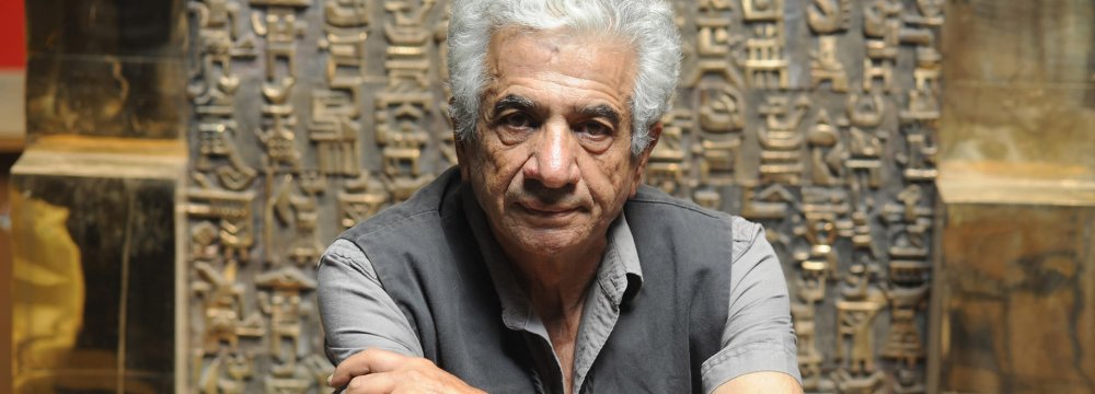 Parviz Tanavoli with his bronze sculpture The Wall (Oh Persepolis).