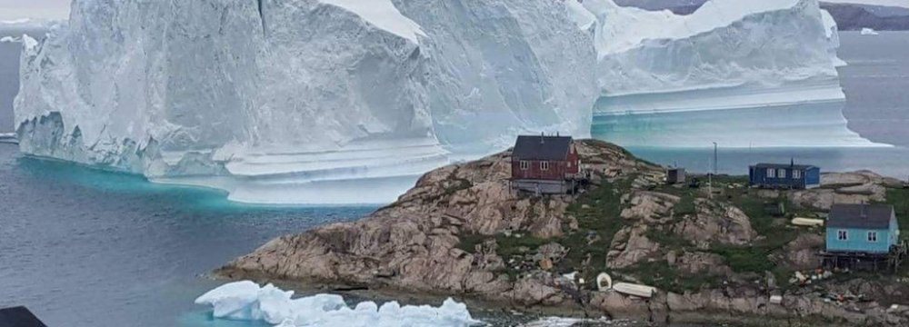 Huge Iceberg Drifts Close to Greenland Village 