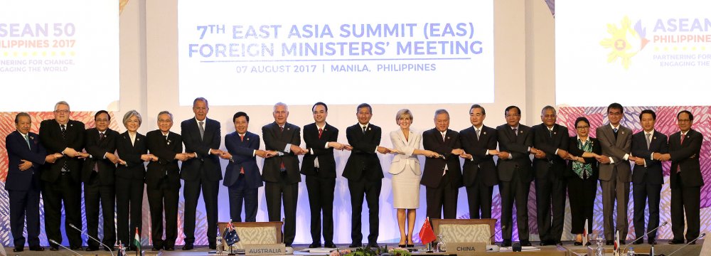 Foreign ministers from Southeast Asia and their dialogue partners link arms during the group photo at the start of the 7th East Asia Summit Foreign Ministers’ Meeting and its dialogue partners  as part of the 50th ASEAN regional security forum in Manila on August 7.